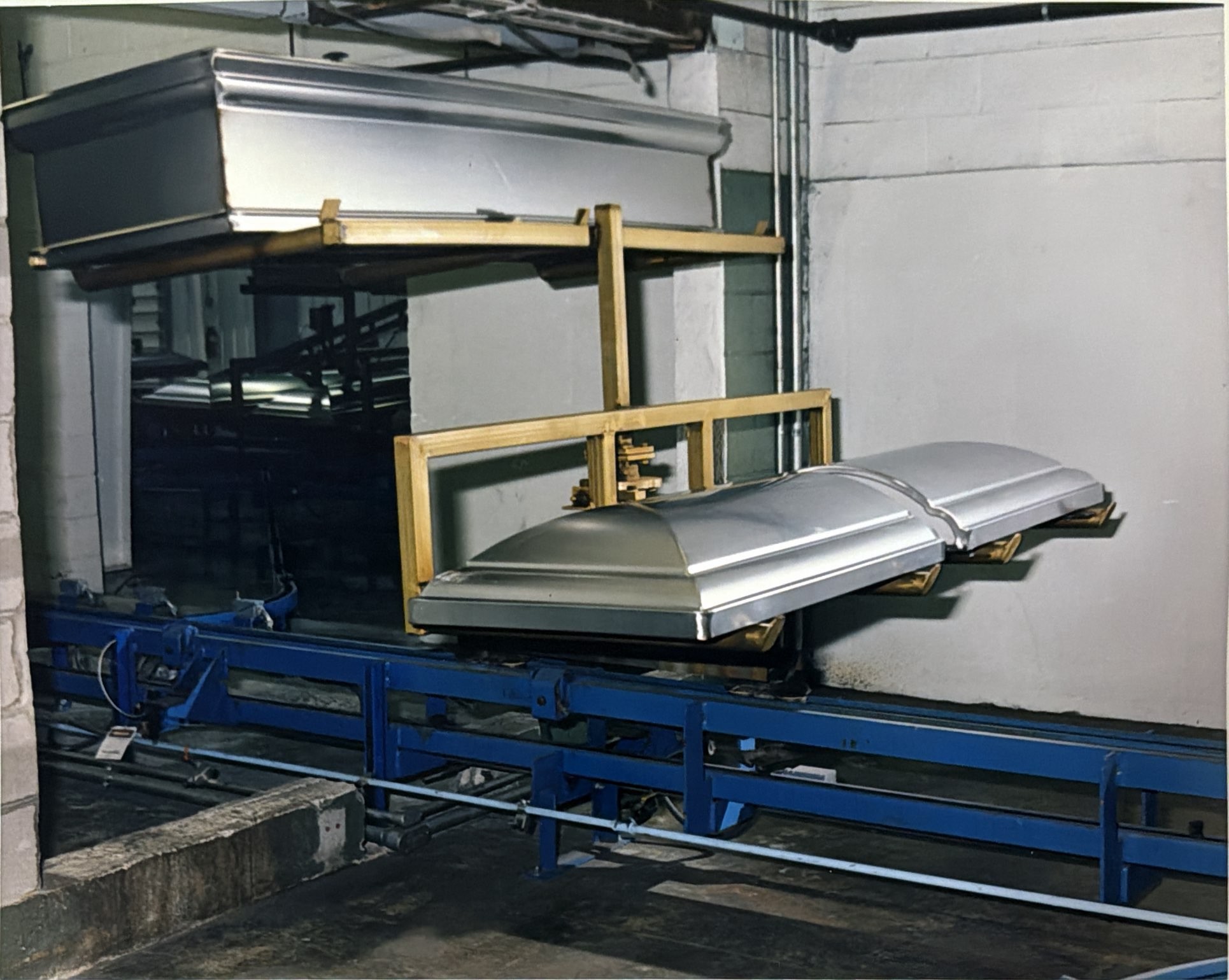 A carrier and metal components at a process opening along the inverted conveyor.