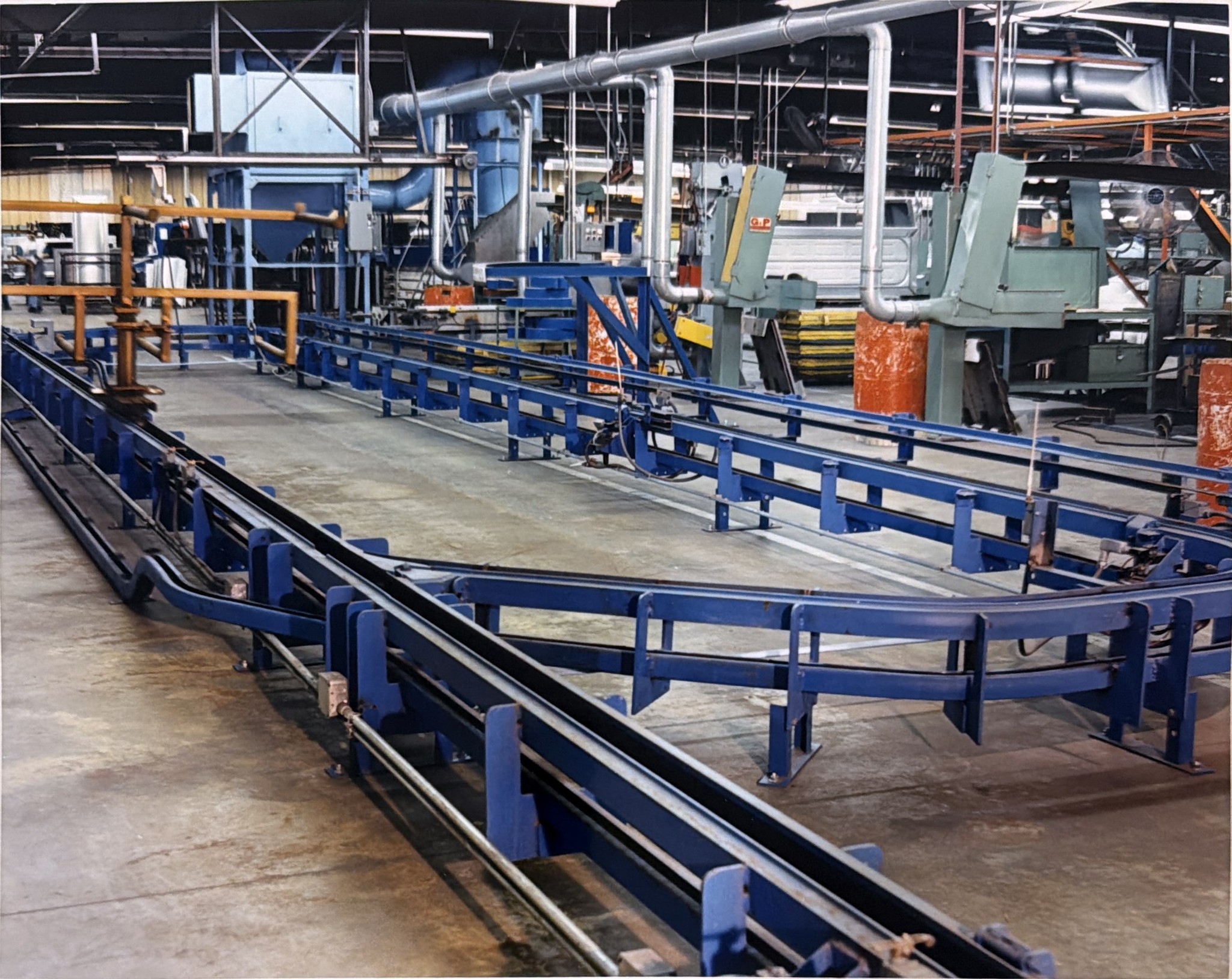 The inverted power-and-free route and support frames alongside production equipment.