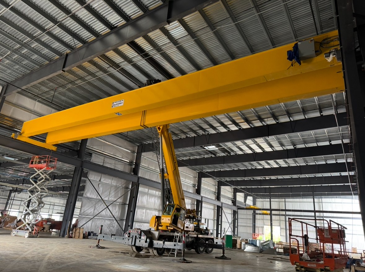 The bridge girders overhead with the mobile crane positioned below during installation.