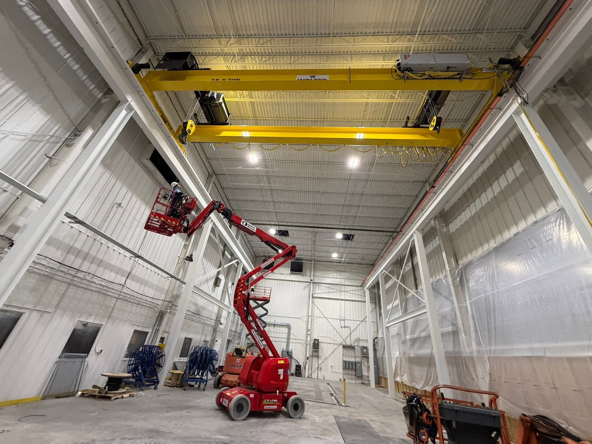 The replacement 38.5-ton bridge crane above the installation bay, with access equipment below.