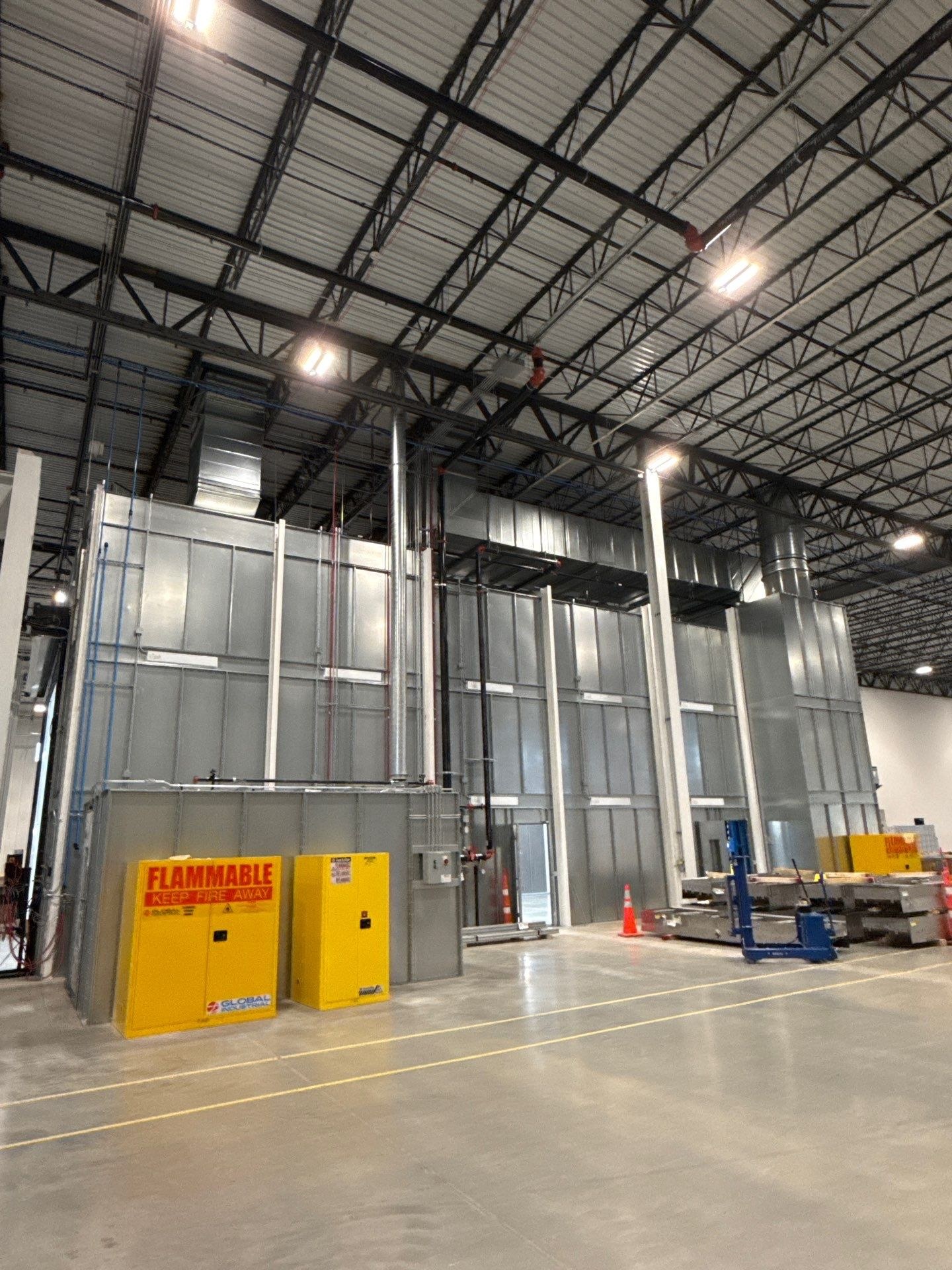 Booth enclosure, overhead ductwork, and adjacent mix-room equipment.