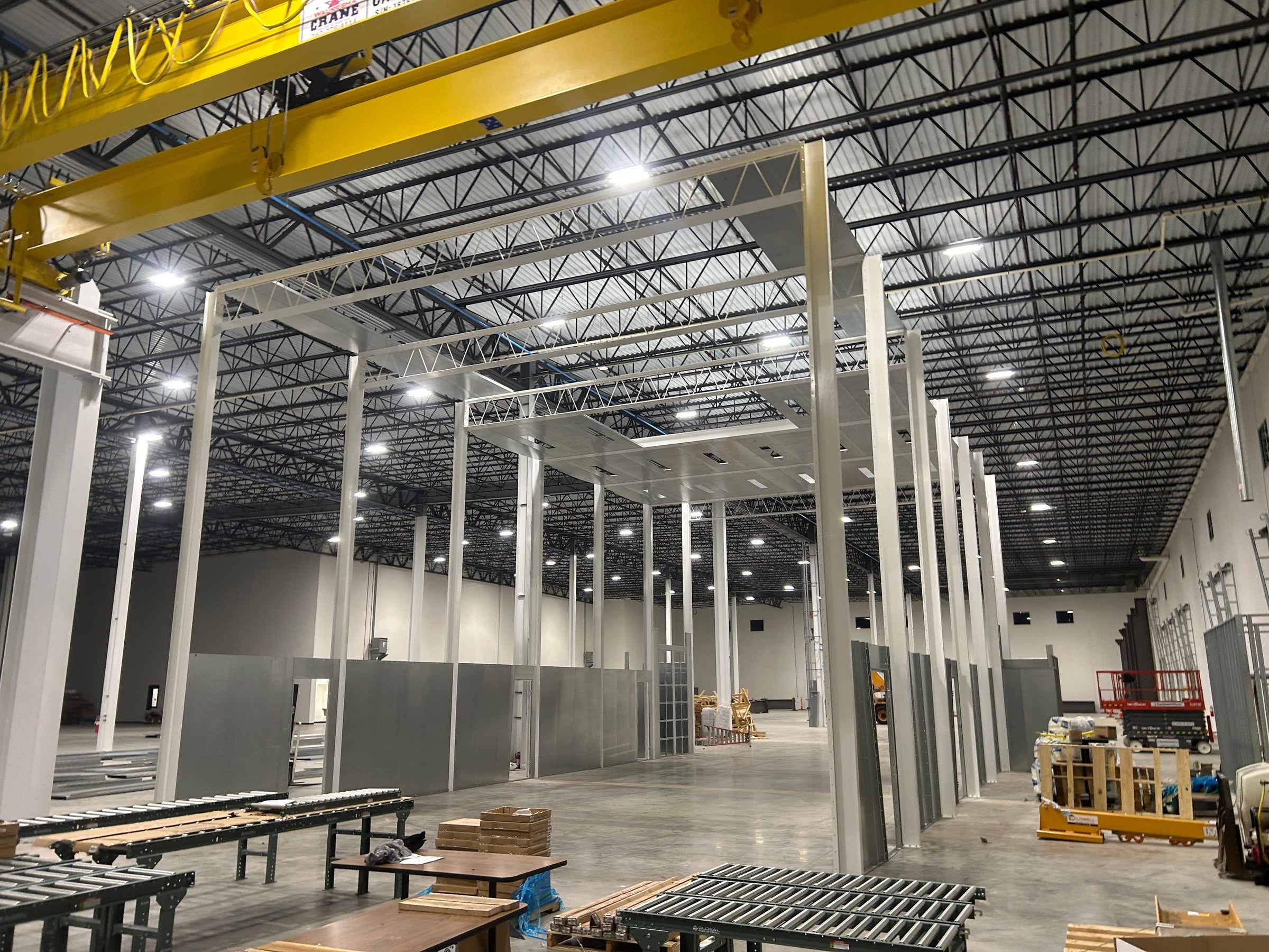 Wide view of the booth framework, partial ceiling, and wall panels during assembly.