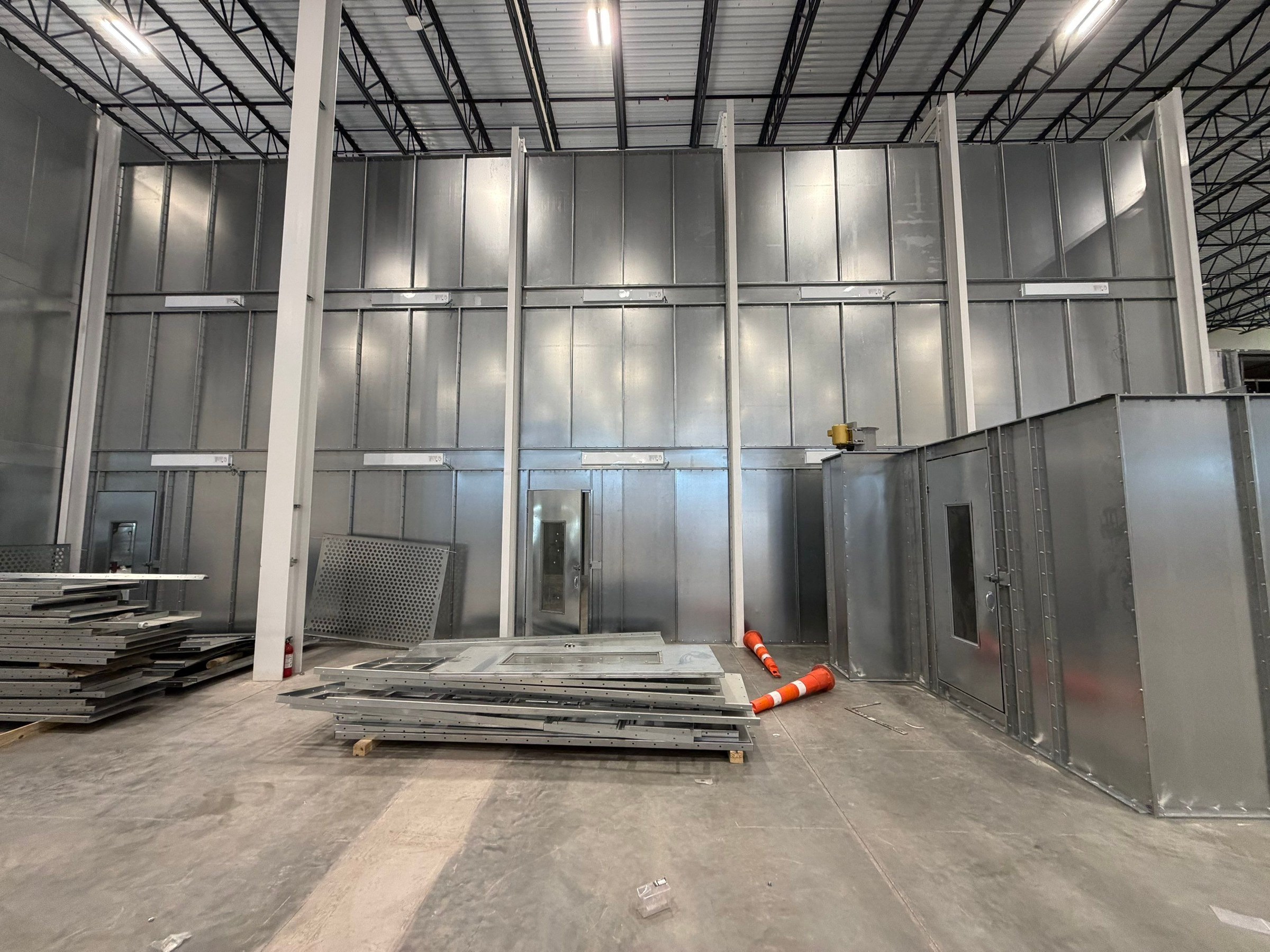 Booth sidewall and adjacent mix-room enclosure with panels staged for installation.