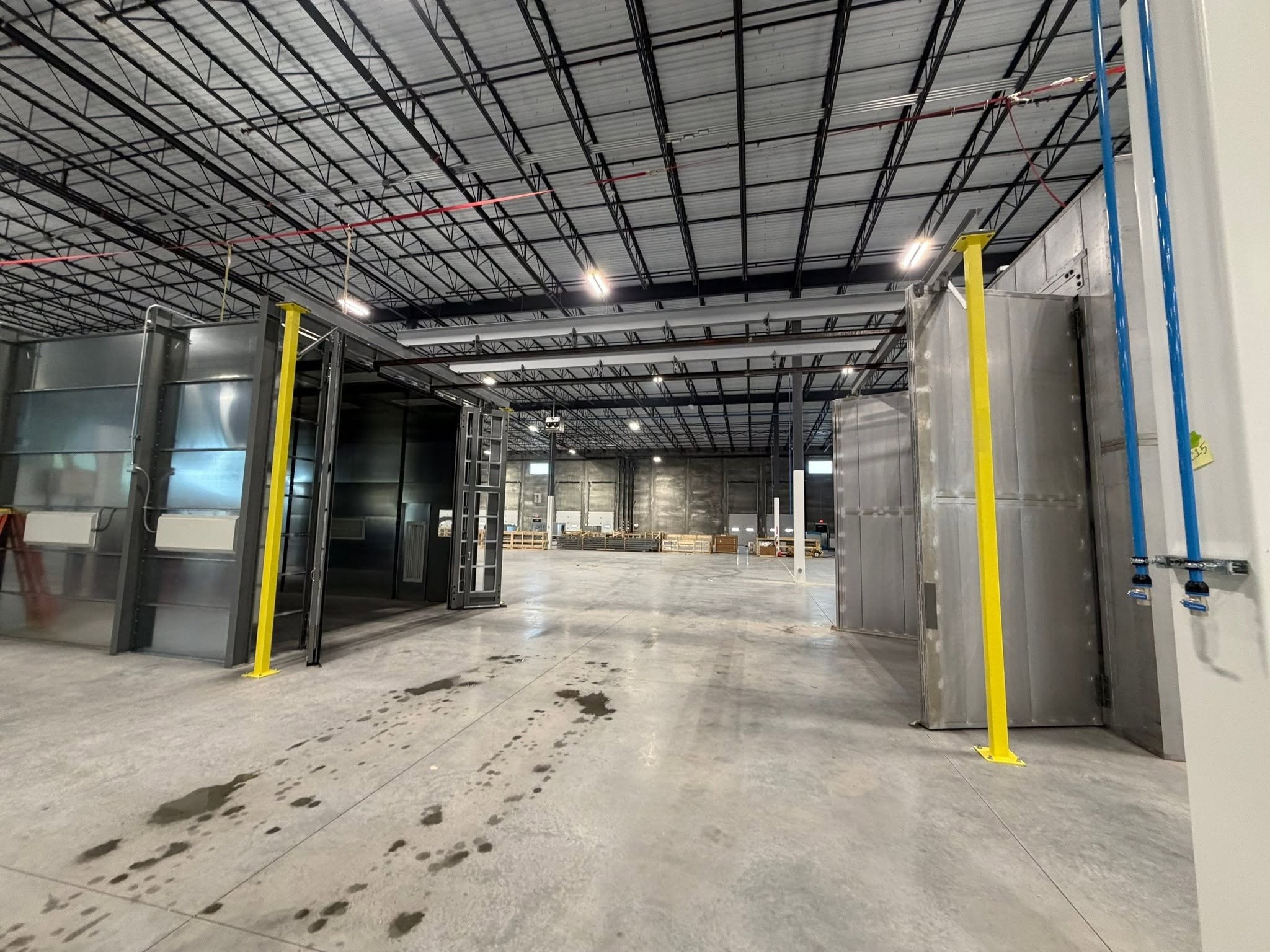 View across the transfer area between the powder-coating process enclosures.