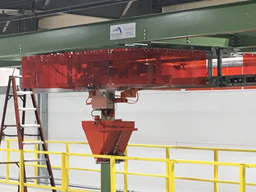 Electric monorail carrier and suspended container beneath the green supporting frame.