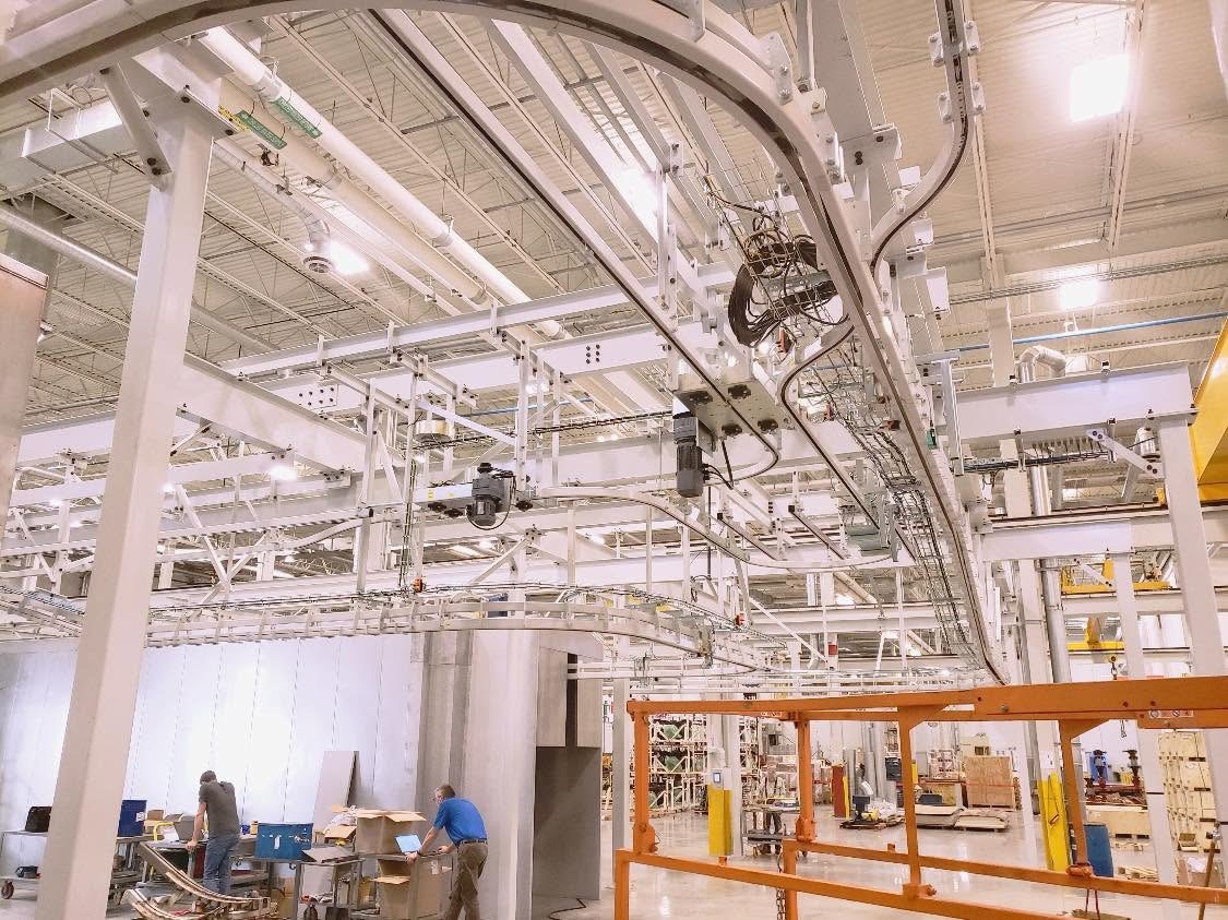 Curved overhead track, conveyor equipment, and support connections at the Gainesville installation.
