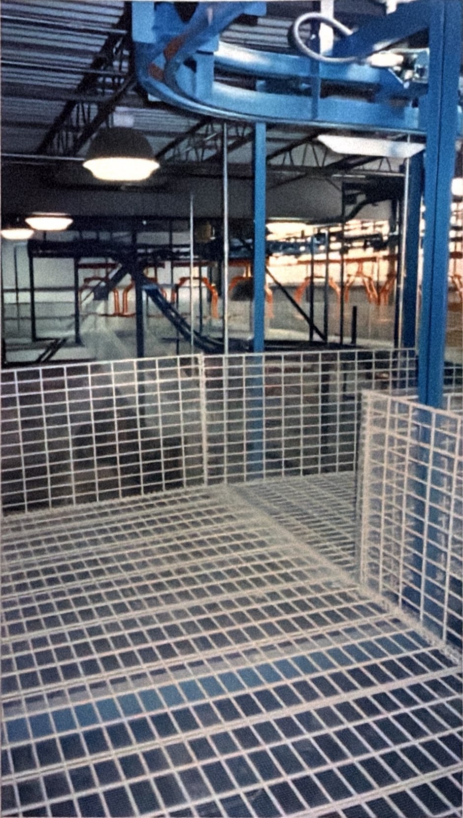 A curved track section and its supporting steel above white mesh guarding.