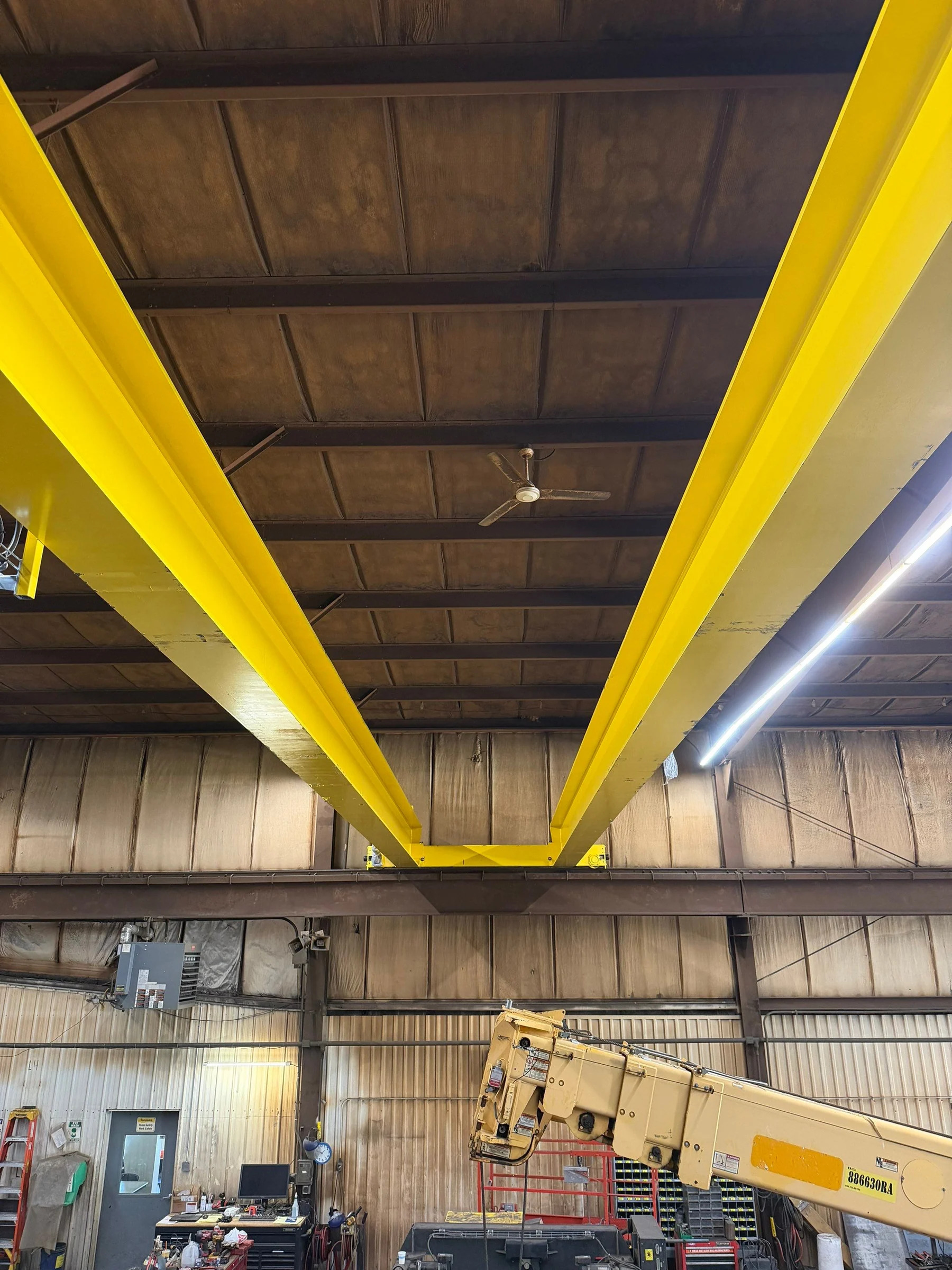Underside view between the two yellow girders of a replacement crane during installation