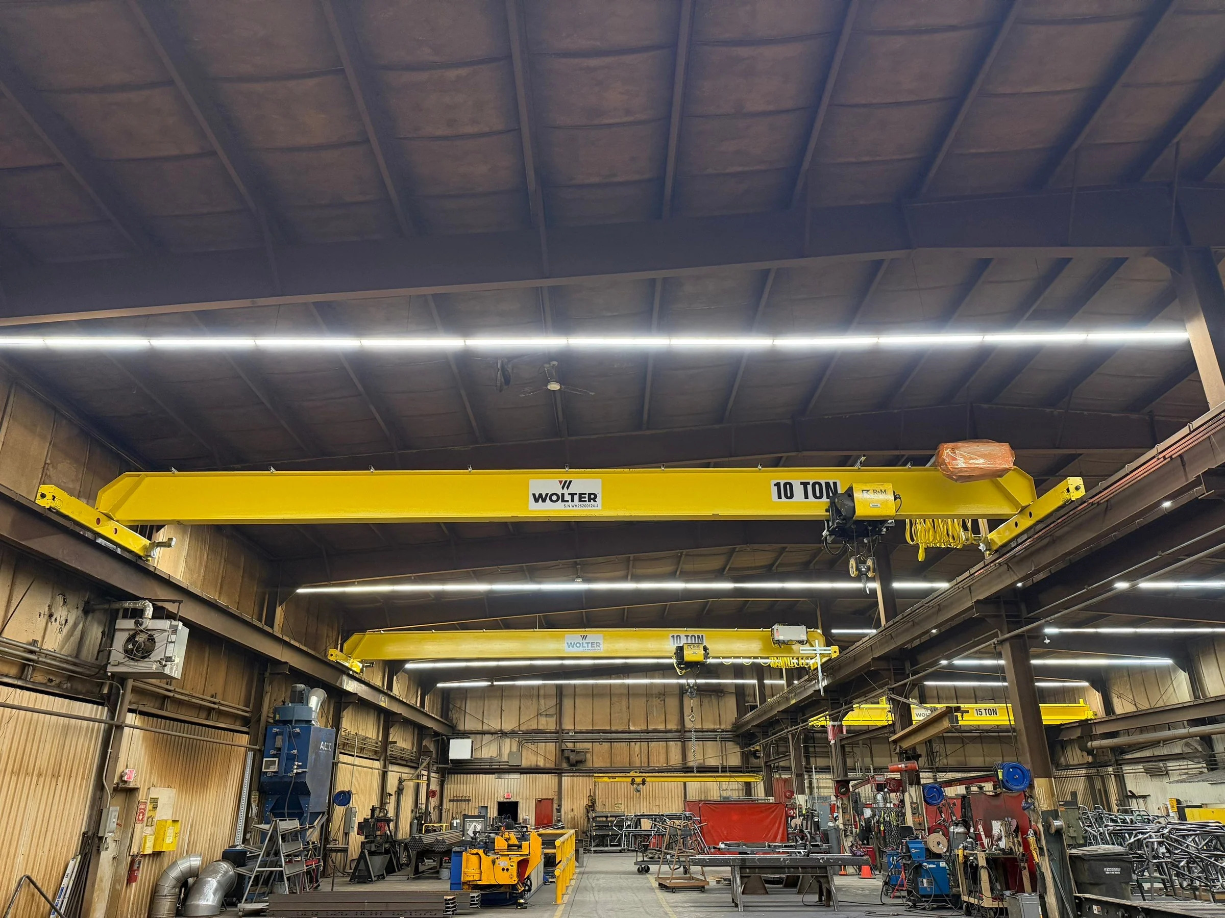 Two new 10-ton bridge cranes in the foreground with replacement 15-ton cranes visible farther into the Lejeune facility