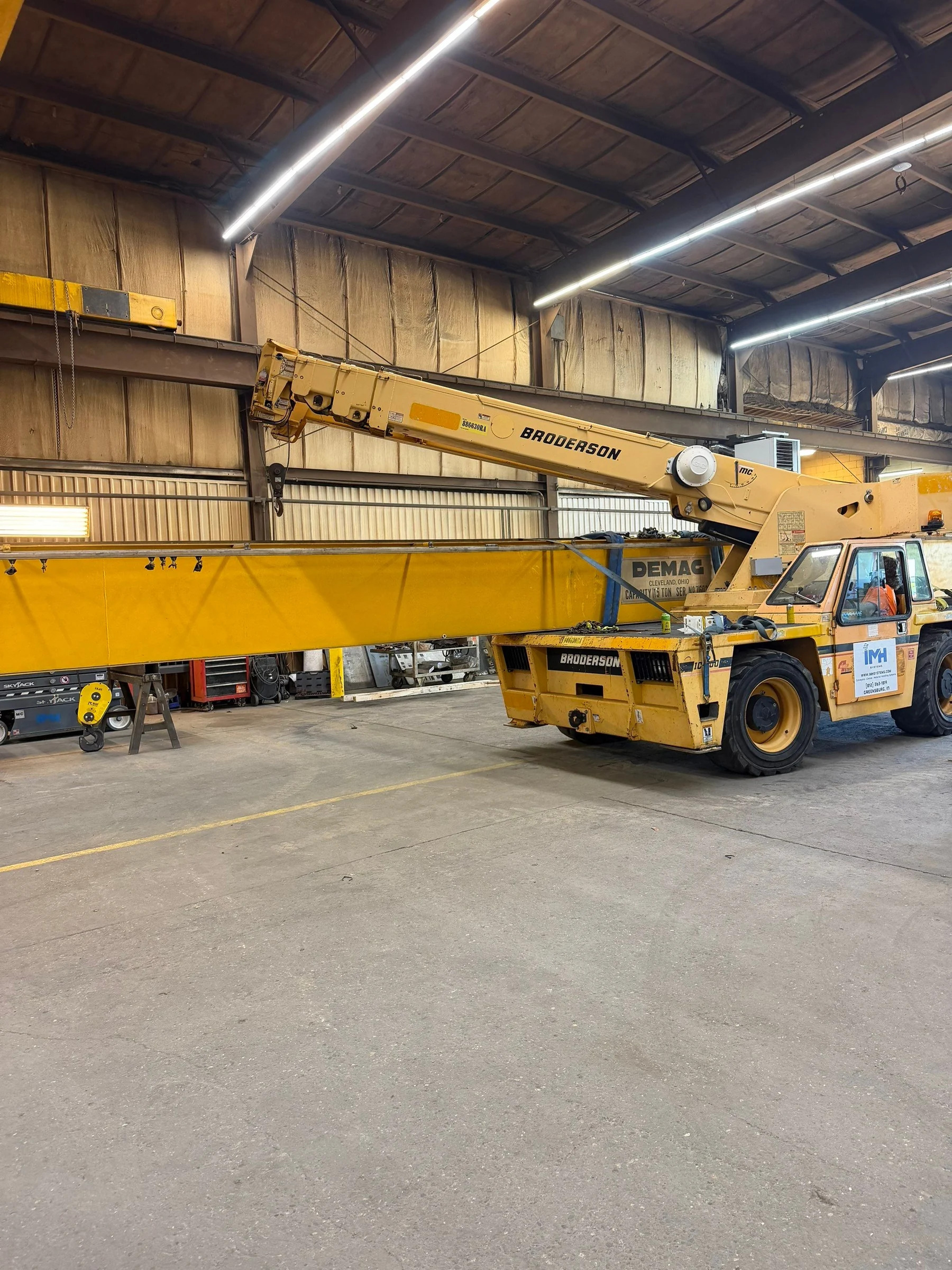 Old Demag bridge girder lowered alongside the IMH mobile crane inside the shop