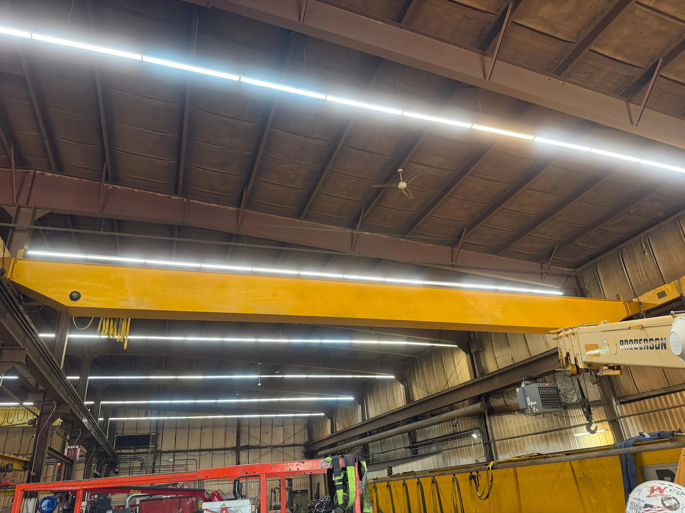 Existing overhead bridge and a lowered girder beside removal equipment within the crane bay