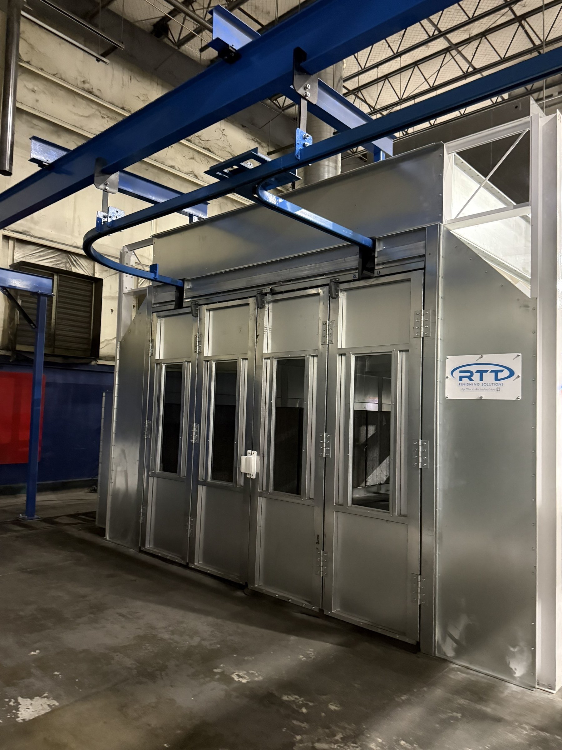 Conveyor track and supporting beams above the booth access doors.