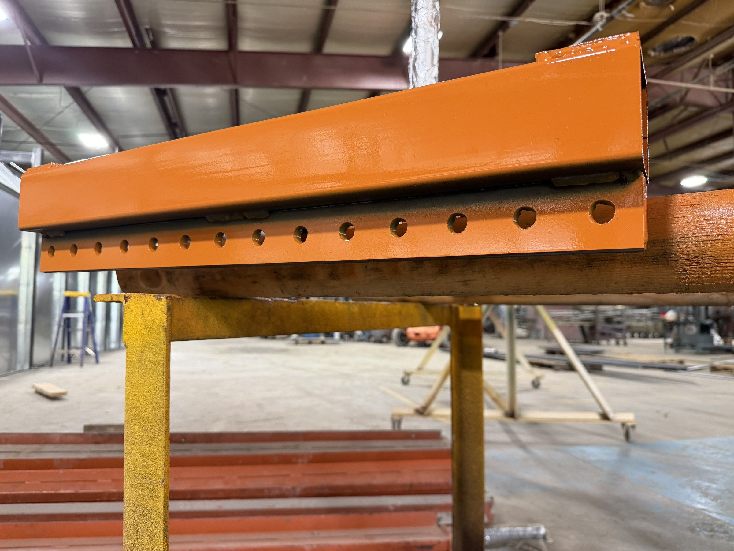 Close view of the carrier rail, hole pattern, and fabricated connections.