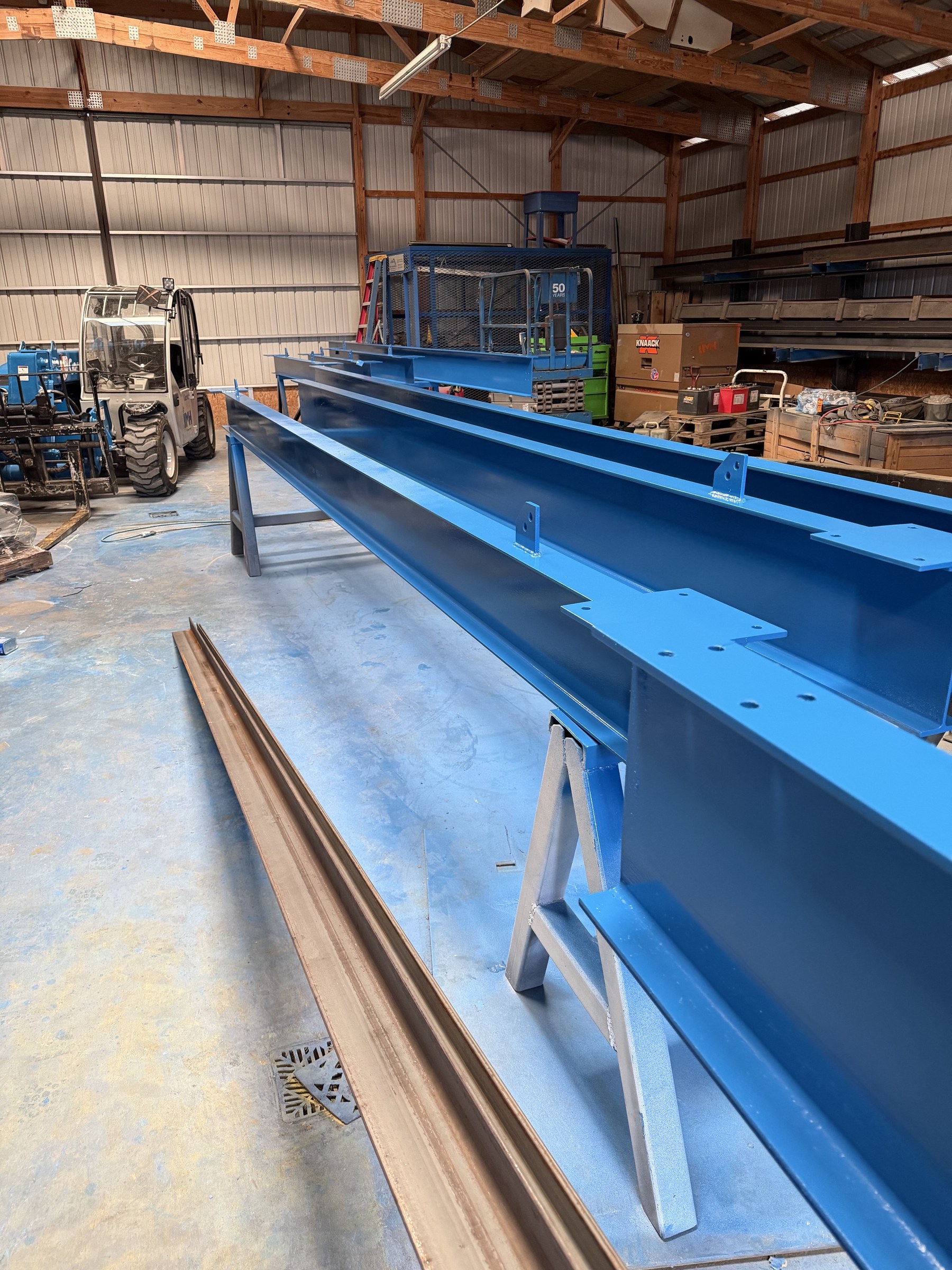 Fabricated blue support beams prepared in the shop.