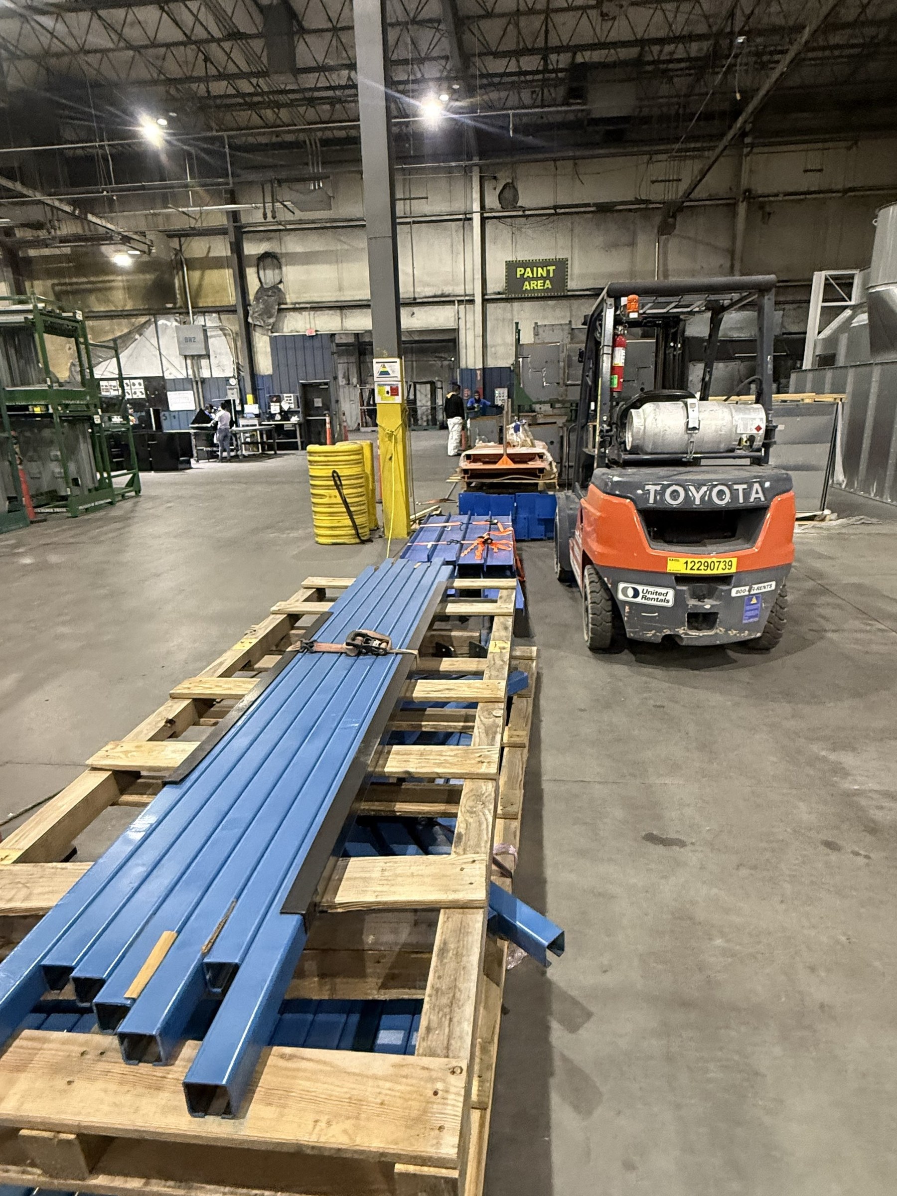 Fabricated blue steel members staged in the plant for installation.