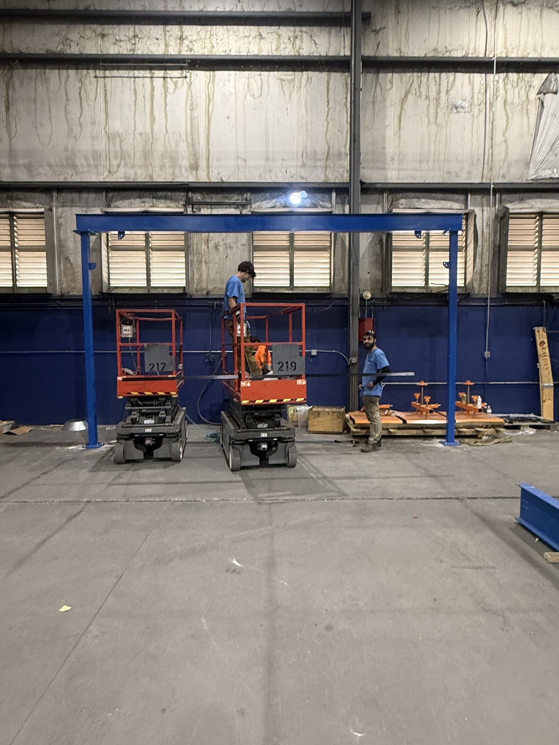 The first blue support frame erected beside installation equipment.