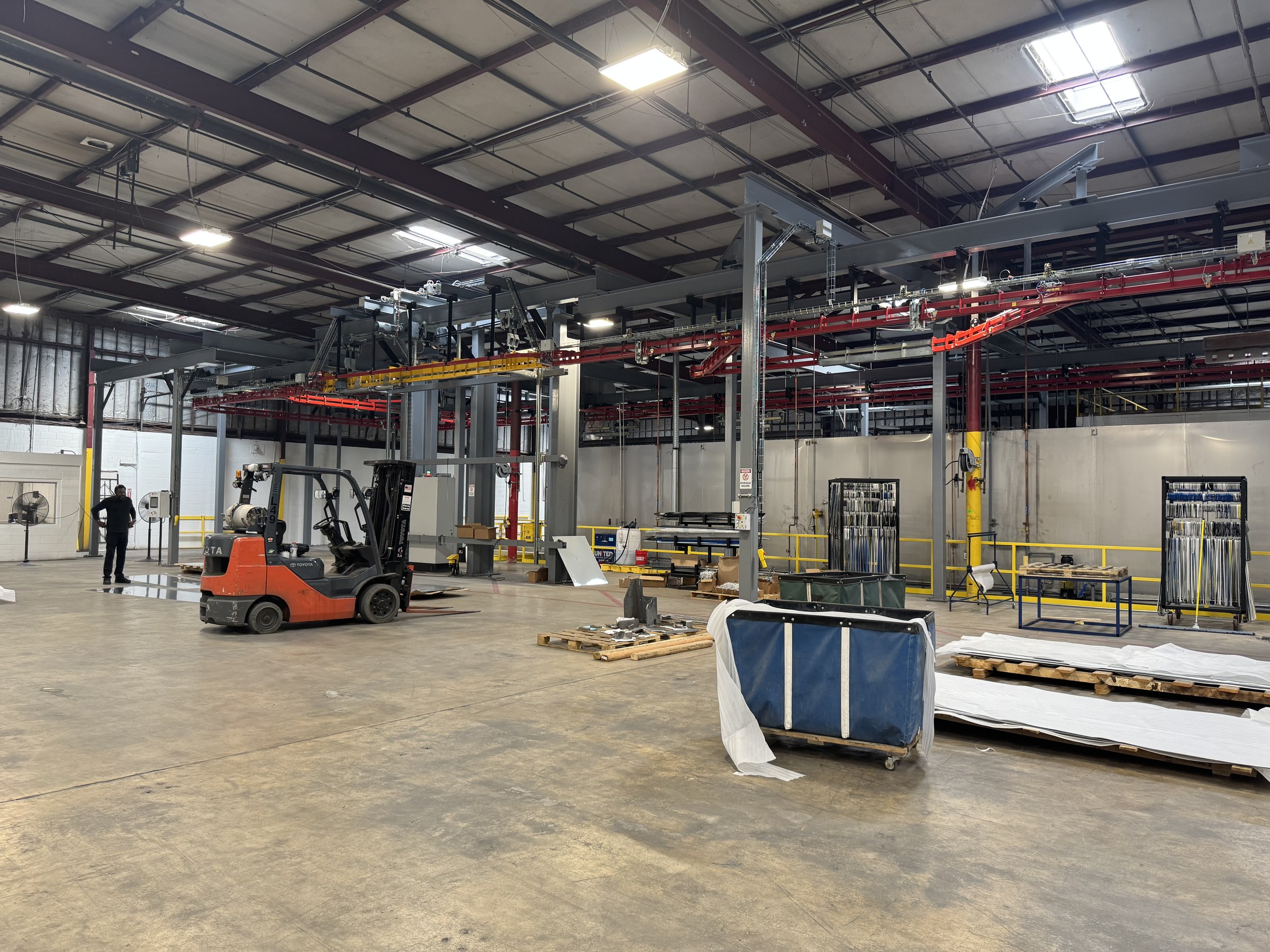 Wide field view of the conveyor and finishing equipment with installation materials on the floor.