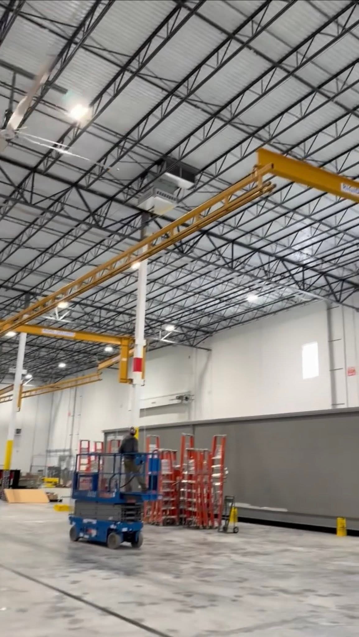 The overhead rigid-lifeline arrangement above the fabrication work area.