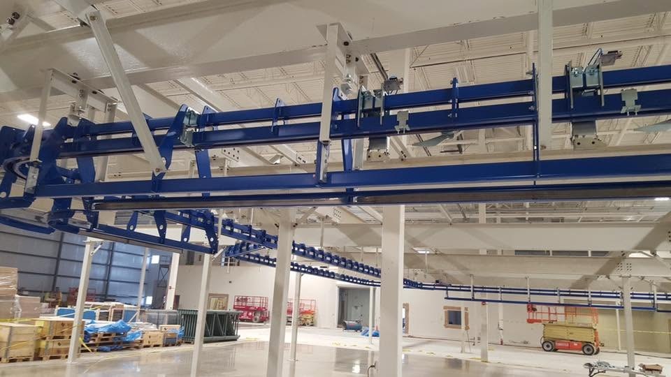 Power-and-free track, suspension brackets, and bolted support connections at the Toledo project.