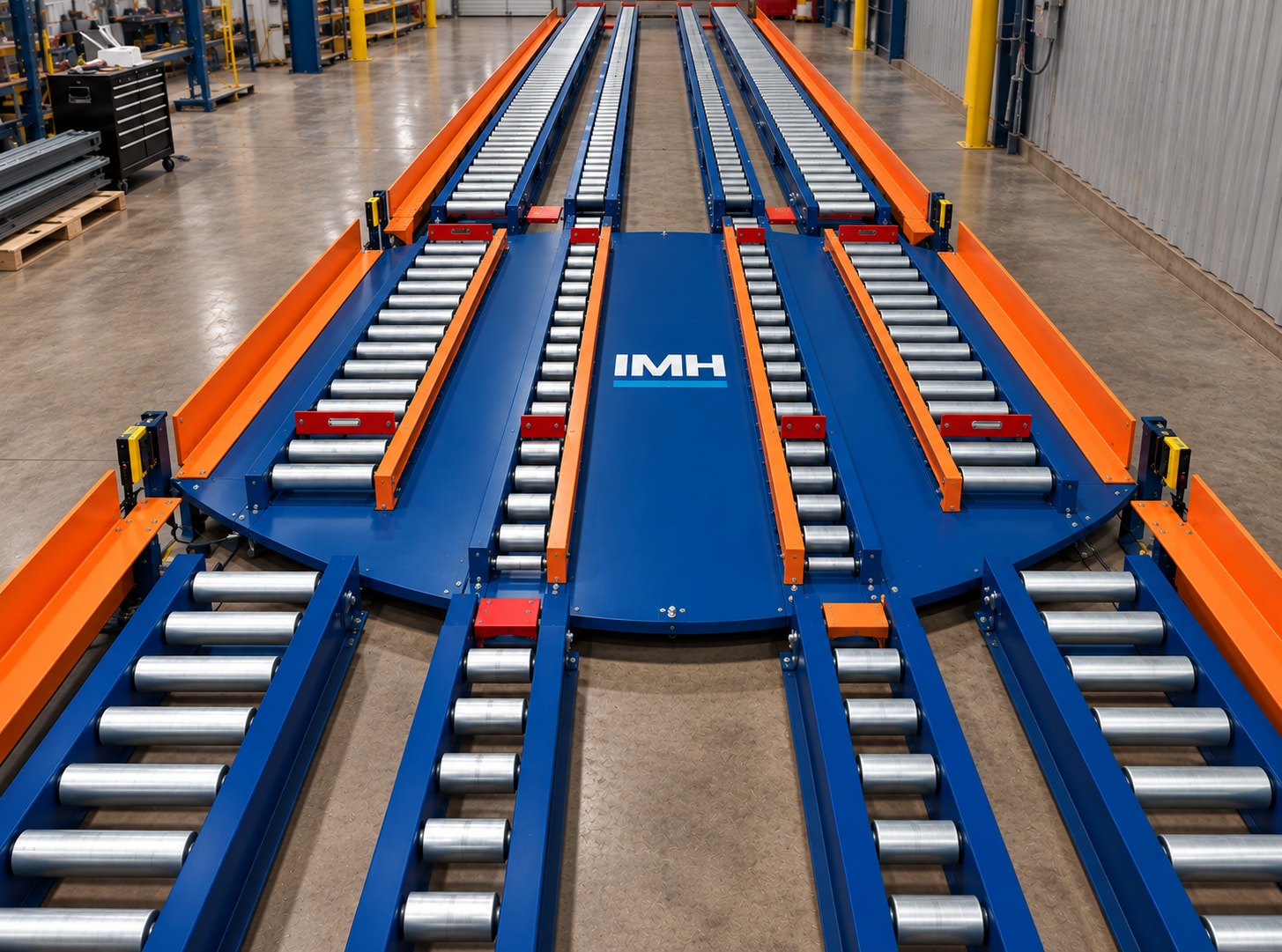 Blue and orange roller conveyor lanes mounted across a circular turntable in a workshop.