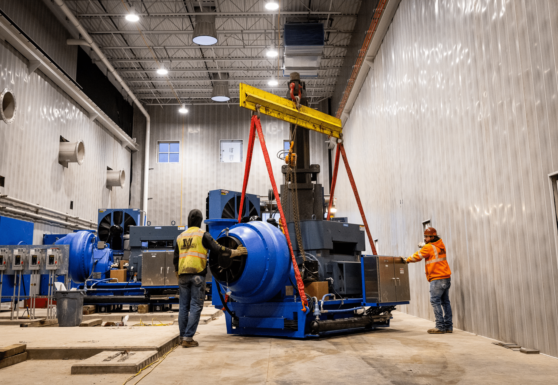 Industrial crews lifting a blue production unit during emergency repair work