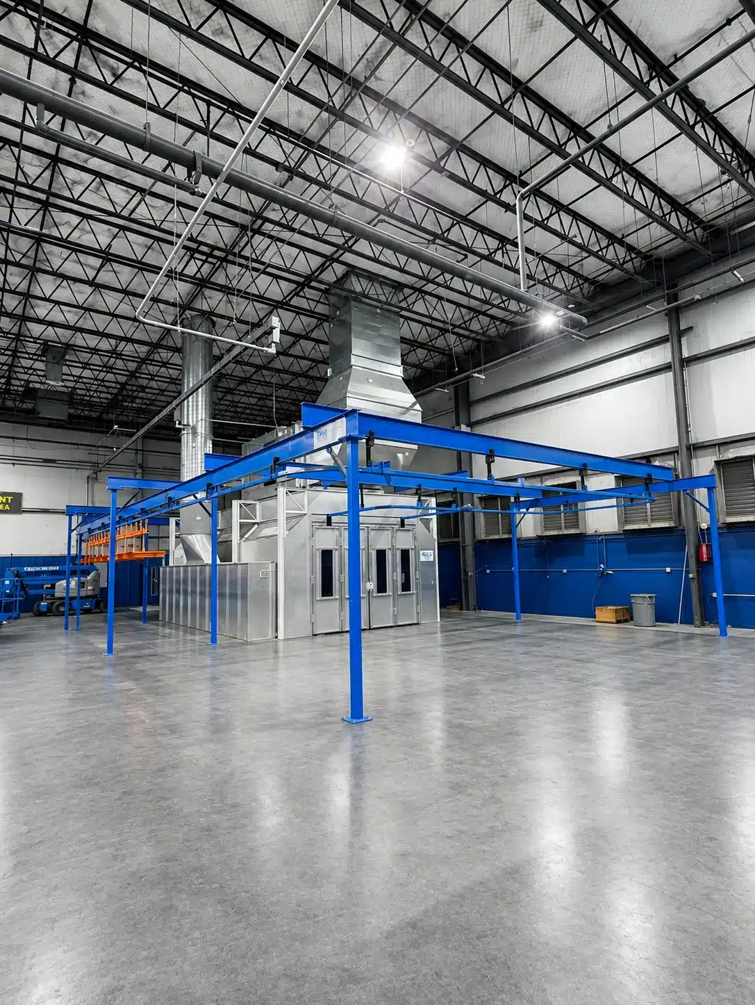 Blue enclosed track conveyor and support steel around an industrial finishing line