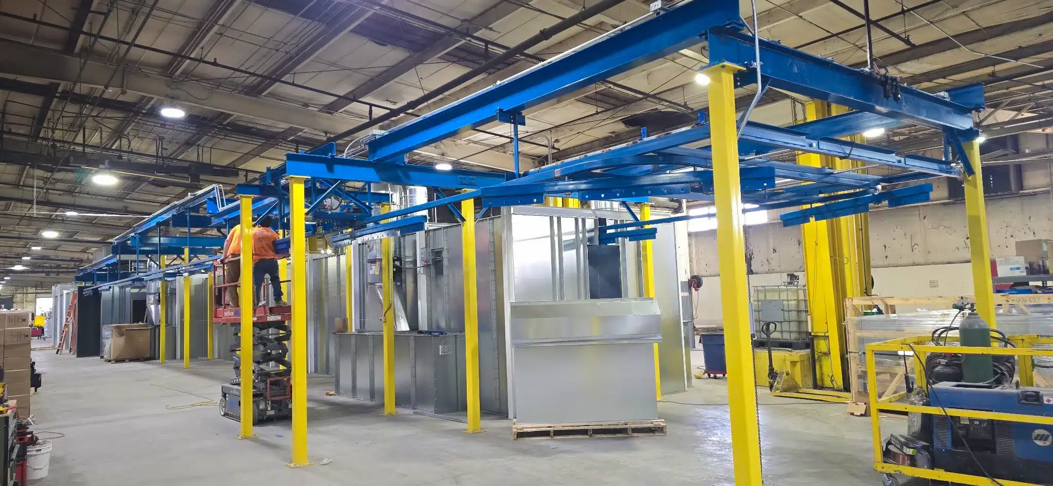 Enclosed track conveyor system installed around an industrial finishing line