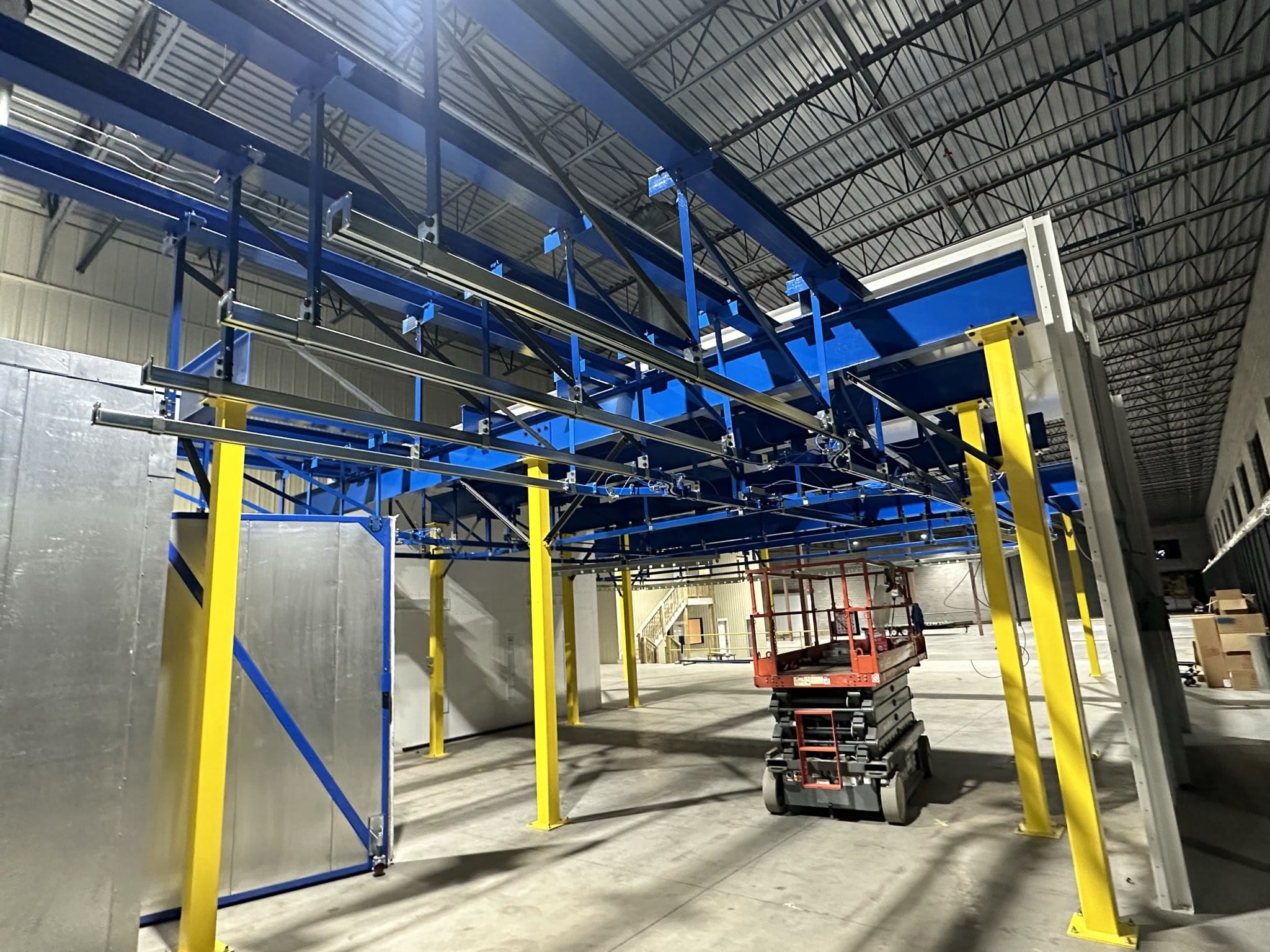 Hand-pushed monorail conveyor installation in a manufacturing facility
