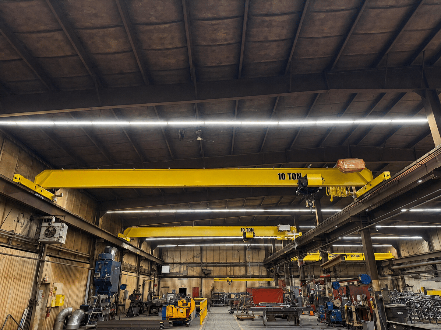 Single-girder bridge crane system in an industrial fabrication facility