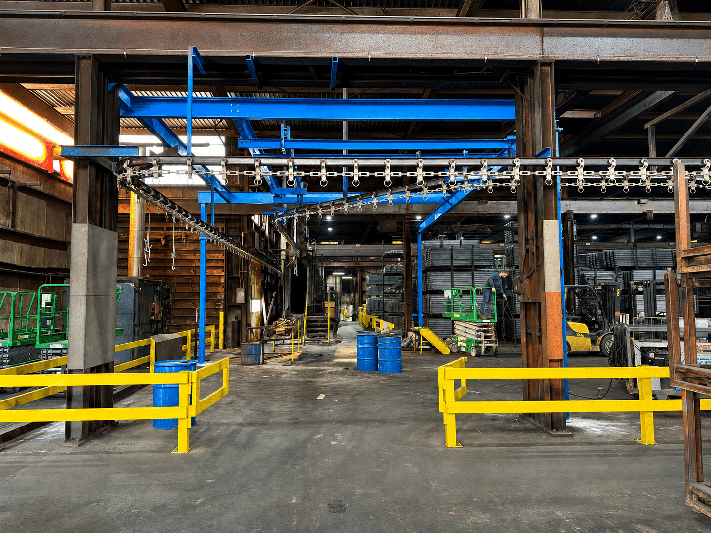Blue overhead conveyor system in an industrial manufacturing facility